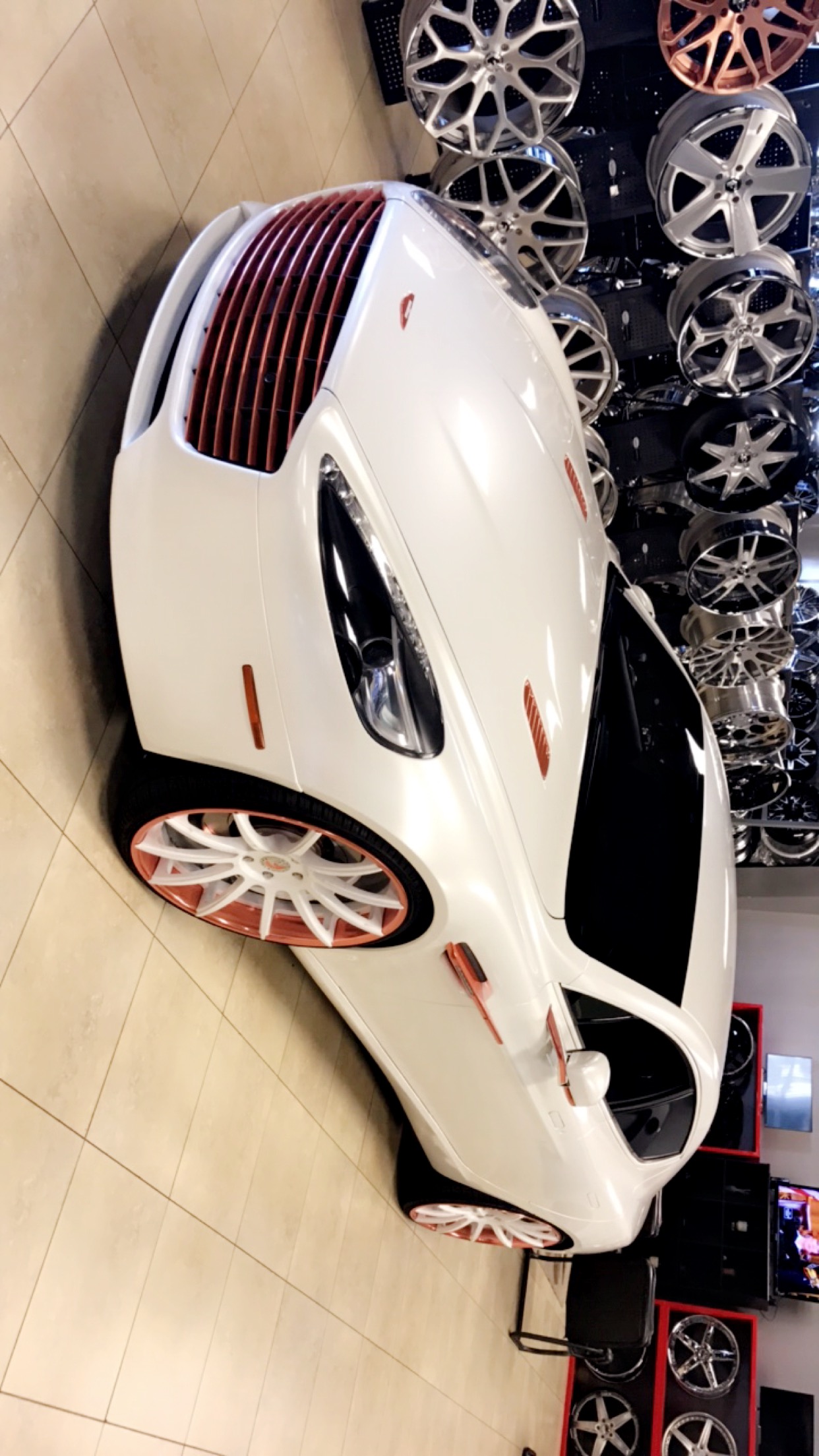 Pearl-white Aston Martin with coordinated rose-gold details.