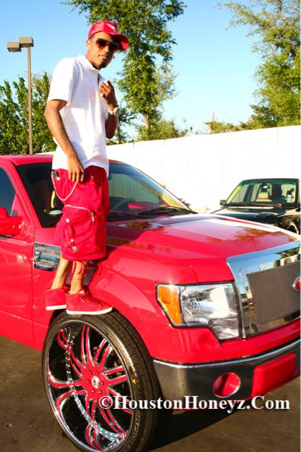 Red custom Ford truck with dramatic wheel styling.