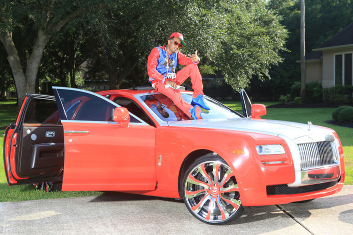 Red Rolls-Royce with oversized custom wheels.