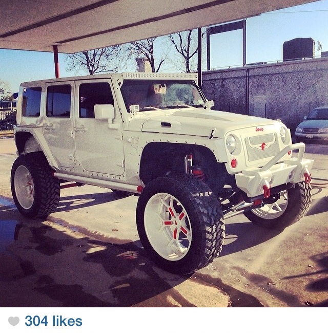 White lifted Jeep Wrangler with oversized wheels.
