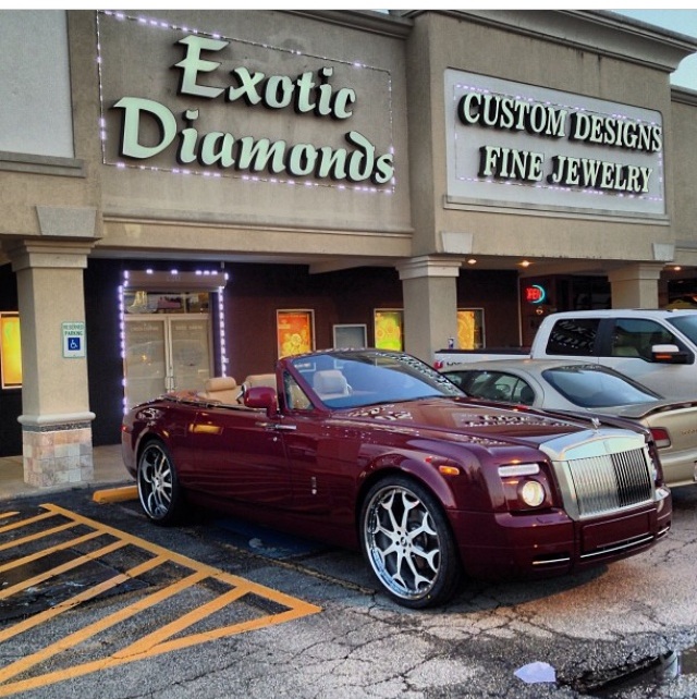 Burgundy Rolls-Royce convertible with custom wheels.