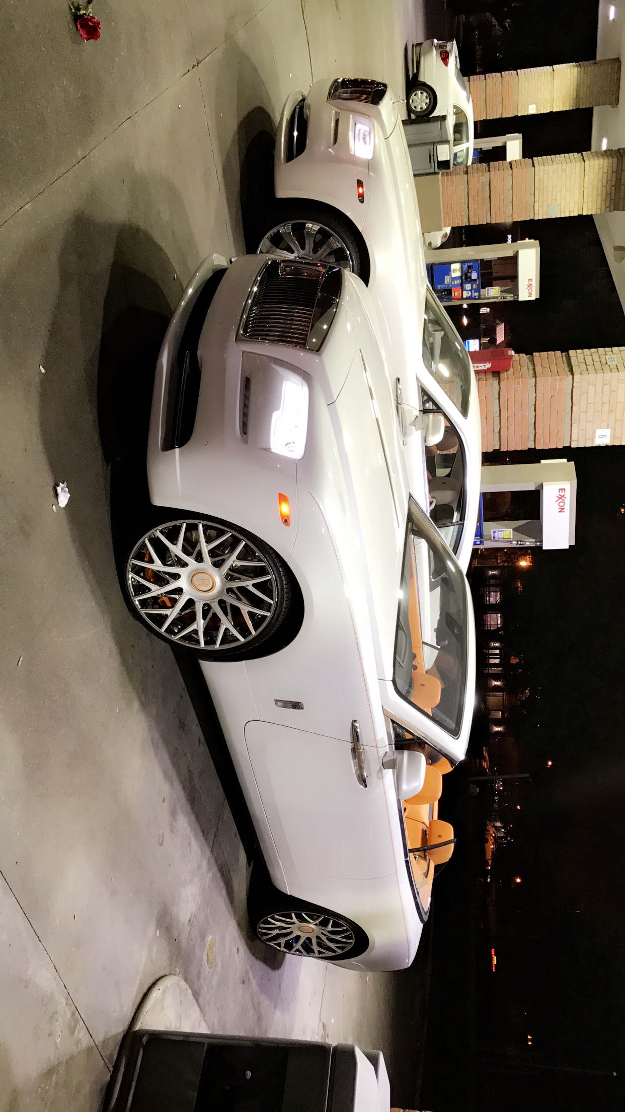 White Rolls-Royce convertible with orange interior.
