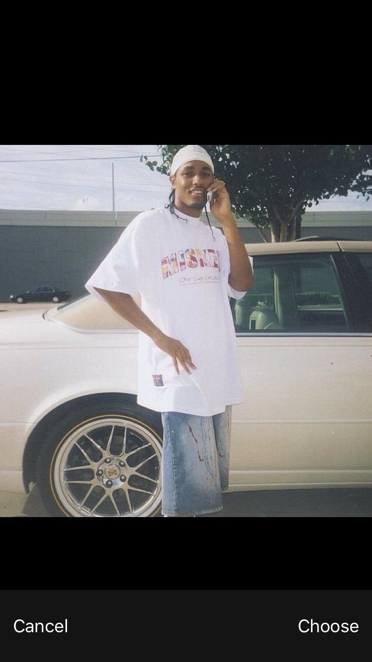 Young adult standing by a car